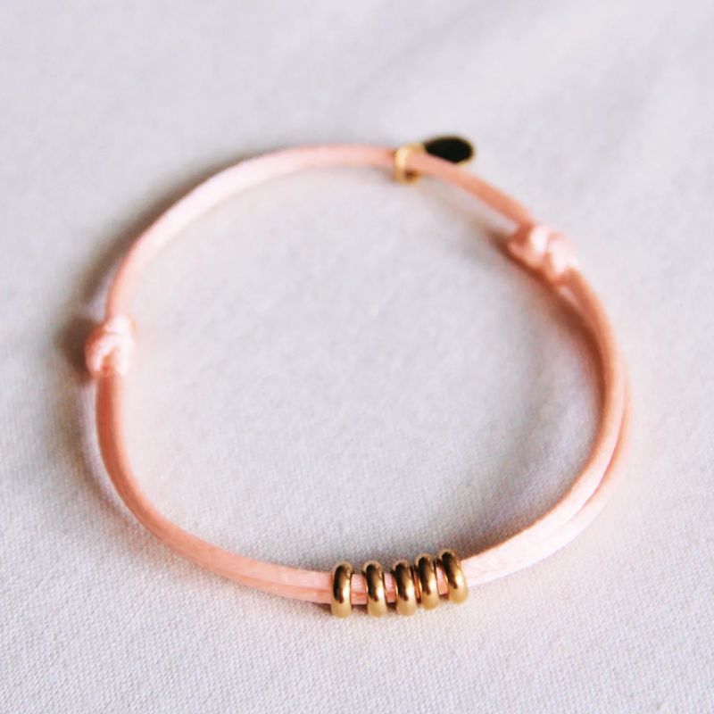 bazou armbandje goudkleurig goud gouden ringen ringetjes lief zalmkleurig armband schuifknoop satijnen bandje satijn bandje glans draad rvs stainless steel roze oranje